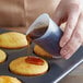 A person pouring syrup from a syringe into an iSi Flex-it mini measuring cup.