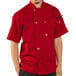 A man wearing a Uncommon Chef red short sleeve chef coat.