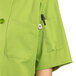 A white Uncommon Chef short sleeve chef coat with a pocket and buttons.