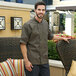 A man in a Uncommon Chef olive short sleeve chef coat standing outside.