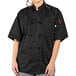 A woman wearing a black Uncommon Chef short sleeve chef coat.