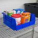 A Metro blue stack bin filled with food on a table.