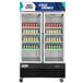 An Avantco black swing glass door merchandiser refrigerator full of drinks.