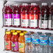 An Avantco glass door refrigerator with shelves of bottled drinks.