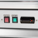 A close up of a switch on a red and white Avantco merchandising refrigerator.