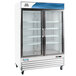 An Avantco white swing glass door refrigerator on wheels with two shelves.