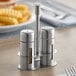 An American Metalcraft salt and pepper shaker set on a table.