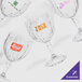 A group of 24 customizable fluted wine glasses with different logos.