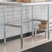 A Regency stainless steel work table with a shelf holding food bags.
