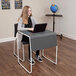 A person sitting at a Luxor desk using a laptop.