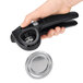 A person using a black OXO Good Grips handheld can opener to open a can.