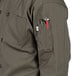 A person wearing an Uncommon Chef olive long sleeve chef coat with pockets and buttons.