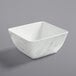 A white square bowl with a marble pattern.
