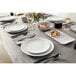 An American Metalcraft marble rectangular melamine platter on a table with a glass of wine and silverware.