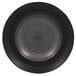 A circular black RAK Porcelain plate with a spiral pattern on the rim.