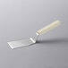 A Dexter-Russell Sani-Safe hamburger turner with a white handle.