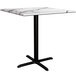 A white table with a marble top and black cross base plate.