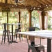 A white Lancaster Table and Seating table with a cross base and chairs on a patio.