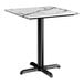 A square standard height table with a smooth Versilla finish top and a black cross base plate.