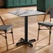 A square standard height table with a smooth Versilla finish and a black cross base plate.