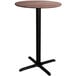 A round Lancaster Table & Seating bar table with a textured walnut finish and black cross base.