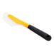 An OXO yellow and black flexible omelet spatula with a handle.