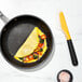 An OXO silicone spatula turning an omelette in a pan.