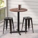 A Lancaster Table & Seating round counter height table with a cross base plate on a porch.