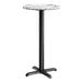 A round bar height table with a smooth Versilla finish top and a black cross base plate.