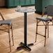 A round bar height table with a smooth Versilla finish and a black cross base plate.