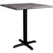 A Lancaster Table & Seating square dining table with a black base and gray top.