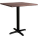 A Lancaster Table & Seating square dining table with a textured walnut top and black base plate.