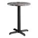 A round standard height table with a smooth Paladina finish top and a black cross base plate.