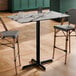 A rectangular bar height table with a smooth Versilla finish and a black cross base plate.