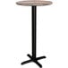 A Lancaster Table & Seating round bar height table with a mixed plank top on a black base.