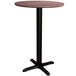 A Lancaster Table & Seating round counter height table with a textured walnut top and black base.