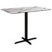 A white Lancaster Table with a marble top and black cross base plate.