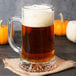 A Libbey glass mug filled with beer on a table.