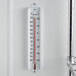 A Taylor cold storage wall thermometer on a white wall.