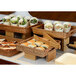 A hotel buffet with food trays on bamboo risers.