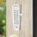 A Taylor 5153 Outdoor Window Thermometer on a wall.
