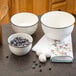 a white bowl with black rim and a white towel with birds on it
