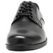 A black Genuine Grip men's oxford dress shoe with laces.