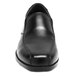 A close-up of a Genuine Grip black slip-on dress shoe with a leather sole.