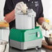 A person using an AvaMix commercial food processor to shred cheese.