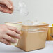 A person pouring ice into a plastic bag.