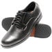 A pair of men's black leather Genuine Grip oxford shoes with rubber soles.