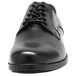 A black Genuine Grip men's oxford shoe with laces.