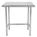 An Advance Tabco stainless steel work table with an open base and metal legs.