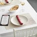 A table set with a RITZ Oatmeal Grass Cloth placemat, a plate, and wine glasses.